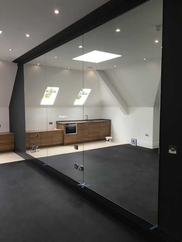 Frameless glass partition in loft conversion by Plumstead glaziers